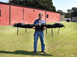 Business development specialist Byron Johnson demonstrates a portable kit of lightning protection